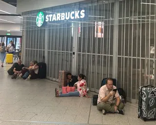 People sit outside the closed Starbucks at Gatwick airport in West Sussex.
