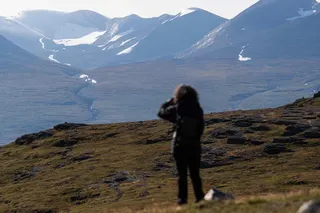 A tourist takes photos of Mount Nuolja, overlooking Abisko in northern Sweden, on August 26, 2021. Photo: AFP