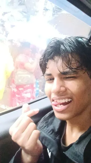 Harshvardhan Kadam winks and smiles at the camera, with his tongue between his teeth. He is wearing a black top and appears to be clicking his fingers.