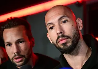 Andrew Tate and his brother Tristan look directly at the camera under red lighting