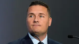 Defence Secretary Wes Streeting speaking at the Farnborough International Airshow in Hampshire. He is wearing a dark blue suit, pale blue shirt, and black tie.