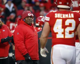 Eric Bieniemy stands on the sideline and yells to a player during a Kansas City Chiefs game.