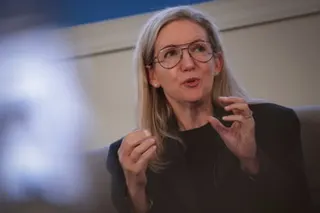 Julie Felss Masino gestures with both hands raised while speaking at an event
