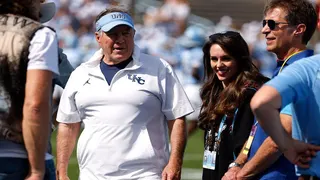 Head coach Bill Belichick and Jordon Hudson standing on the sidelines at Kenan Memorial Stadium.