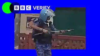 A still from a video of a rapid action force officer in Delhi, raising what experts say is a pellet gun.