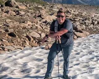 A man standing near snow and rocks