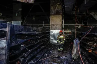 A Ukrainian firefighter inspects the site of a supermarket in Chernihiv that was hit by a Russian drone. [REUTERS/Maksym Kishka]