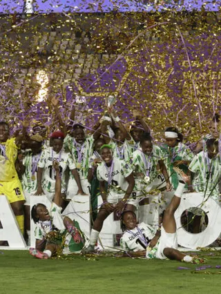 Nigeria's players celebrate with the trophy on the podium after winning the 2025 Women's Africa Cup of Nations final football match against Morocco at Prince Moulay Abdellah Stadium in Rabat on July 2