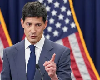 a man in a suit speaks into a microphone