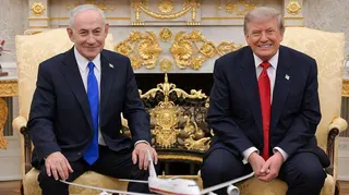 Netanyahu and Trump smile towards the camera during their meeting at the White House