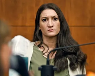 a woman sitting in courtroom looks ahead