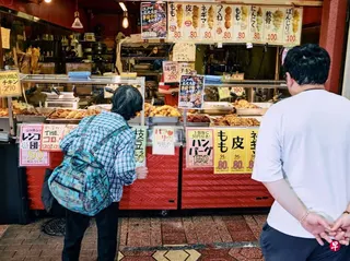 7月22日，在日本东京的一个食品摊位，顾客们正在等待取餐。 （彭博社）
