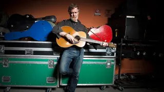 Glen Hansard poses for a photo while playing guitar