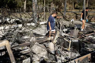 A woman and her daughter searching through the rubble of their campsite cabin on July 30, in El Barraco, 100km west of Madrid.