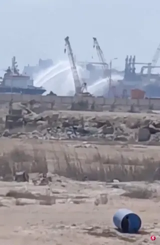 社媒视频截图显示，7月29日，埃及达米埃塔港一艘遭无人机袭击的天然气储运船正在接受水炮喷射救援。 （路透社）