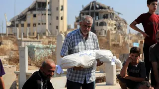 A relative carries the body of Palestinian girl Amira al-Masri, who was killed along with her parents and three of her siblings in an Israeli strike on their home in Gaza City (21 July 2026)