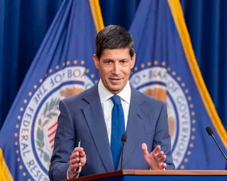 Man at podium with hands spread apart