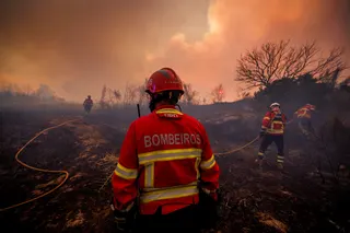 Firefighters battling flames in Valpacos, Portugal, on July 30.