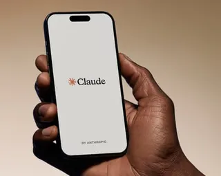 A person holding a phone with the Claude AI app