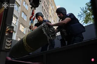 6月28日显示，在乌克兰首都基辅居民楼附近发生空袭后，乌克兰工兵将一枚俄罗斯导弹碎片装载到卡车上。 （法新社）