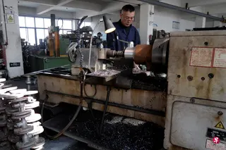 一名工人在中国浙江省温州一家管件阀门配件工厂生产线上工作。 （路透社）