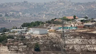 A wide view of Havat Gilad outpost, a cluster of prefabricated buildings perched on a hilltop in the occupied West Bank