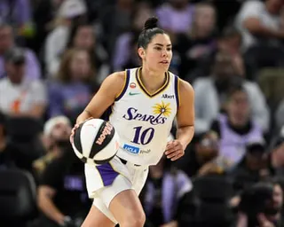 Kelsey Plum in a white Sparks jersey dribbles down the court during a game