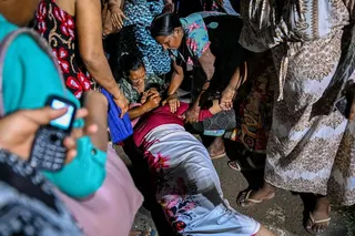 A relative of a Mahara Prison riot victim faints in grief on Saturday. Photo: AFP