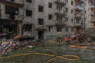 救援人员8月1日在基辅一栋遭俄军空袭损毁的多层住宅楼外工作。（法新社）