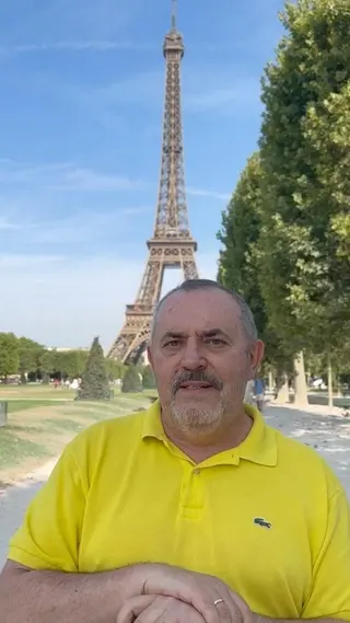 Boris Nadezhdin wears a yellow Lacoste polo shirt while standing in front of the Eiffel Tower on a sunny day in Paris, in this still image from a video released on his Telegram.