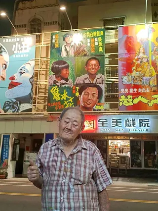 台灣國寶級手繪電影看板畫師顏振發與「魯冰花」大型手繪看板合影。圖／摘自今日全美戲...