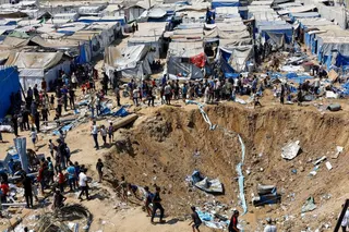 Palestinians inspect the site of an overnight Israeli strike on a medicine warehouse, according to medics, next to tents sheltering displaced Palestinians, in Deir al-Balah, in the central Gaza Strip, August 1, 2026, residents had been pre-warned by the Israeli military to evacuate. REUTERS/Mahmoud Issa REFILE - ADDS INFORMATION