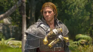 Black Flag Resynced outfits: Edward wearing the Master Assassin Outfit looking towards the camera with a tropical forest in te background.