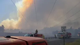 Firefighters respond beneath a massive smoke plume during the Spokane-area wildfires