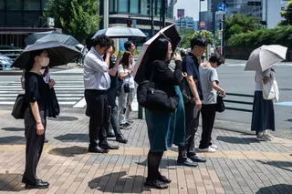 People carry umbrellas to shelter from the sun in Tokyo last month. Photo: AFP