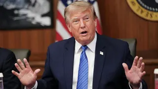 US President Donald Trump raises both his hands while speaking during a Cabinet meeting at Camp David in Maryland on 31 July.