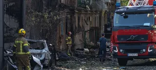 在乌克兰基辅发生的一起袭击事件现场，消防员和消防车被受损的建筑物和瓦砾包围。