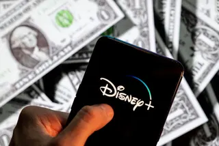 Disney+ (plus), logo seen on an Android mobile device screen with the currency of the United States dollar icon, $ icon symbol in the background