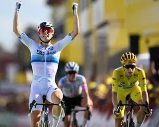 Demi Vollering raises both arms winning the stage, ahead of the yellow jersey rider.