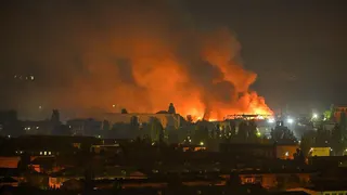 A fire breaks out following massive Russian ballistic missile strikes in the Ukrainian capital of Kyiv, with orange and black plumes of smoke expanding across the night sky.
