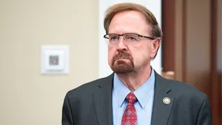 Rep. Chuck Edwards standing in front of a door in a hallway.