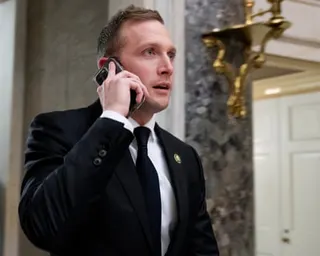 a man in a suit talks on his phone