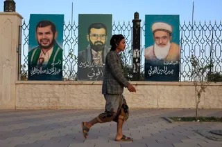 epa12579080 A person walks past paintings on a fence depicting senior Houthi leaders, in Sana'a, Yemen, 08 December 2025. The Yemeni government has announced in a statement that a new round of UN-sponsored talks with the Houthis will be held next week in Oman, as part of a fresh effort to secure the release of hundreds of war prisoners. This comes nearly five years after about 1,000 prisoners from both sides were released, marking the largest exchange since the conflict began in 2014. EPA/YAHYA 