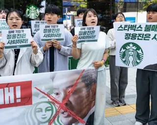 Protesters hold signs demanding a Starbucks boycott and chairman's resignation in Seoul