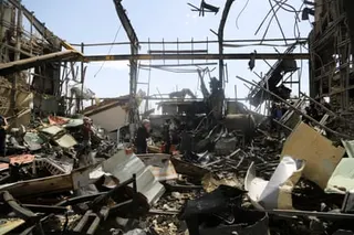 people walk through a destroyed university building