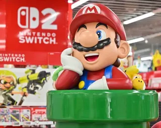 A large Mario figure rests its chin on its hand at a Nintendo Switch 2 store display