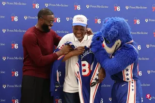 NBA球星布朗（左）在记者会上为庆祝生日的祖父送上新东家76人的球衣当礼物。 （路透社）