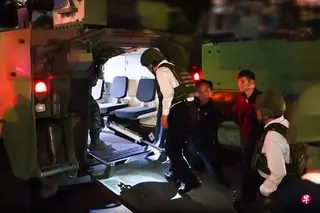 这张取自台湾总统府视频的截图显示，台湾总统赖清德（左一）8月5日夜里首次以三军统帅身份亲自参与汉光演习，穿戴着防弹背心与头盔登上一辆台湾制造的CM32云豹八轮装甲车，前往台国防部大直本部。 （法新社）