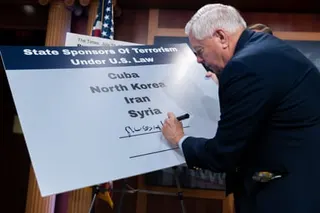 Senator Lindsey Graham writes "Russia" on a poster listing state sponsors of terrorism