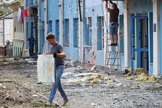 A man carries broken glass outside a bank building damaged during a Ukrainian overnight drone attack, according to local authorities, in Belgorod, Russia on Sunday. Photo: Reuters